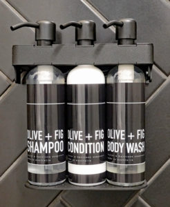 Matte black soap dispenser with Taylor+Harrison Soapware Fig & Olive shampoo, conditioner and body wash.